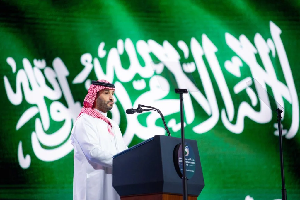 صورة لسمو ولي العهد الأمير محمد بن سلمان أمام علم المملكة العربية السعودية